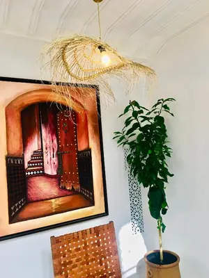 a potted plant and a painting on a wall at Riad Olika in Marrakech