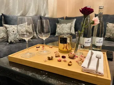 a table with two wine glasses and flowers on it at Duplex Atlas Golf Resort Pοοl νieω Seriniτყ & Cαlm in Marrakech