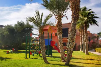 a playground in a park with palm trees at Duplex Atlas Golf Resort Pοοl νieω Seriniτყ & Cαlm in Marrakech