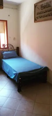 a bedroom with a bed with a blue comforter at Twins 13 in Marrakech