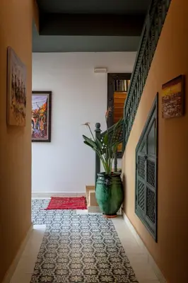 a hallway with a plant in a large vase at Riad les remparts de la kasbah in Marrakech