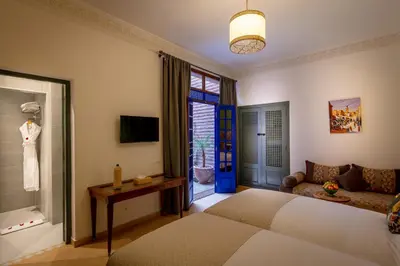 a bedroom with a bed and a couch and a window at Riad les remparts de la kasbah in Marrakech