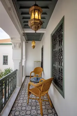 a room with a table and chairs on a balcony at Riad les remparts de la kasbah in Marrakech