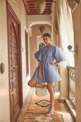 a woman in a blue dress standing in a hallway at Riad Hikaya in Marrakech