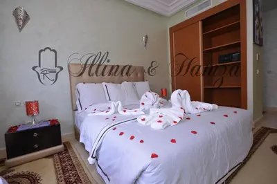 a bedroom with a large white bed with red hearts on it at Illina & Hamza Apartment in Marrakech