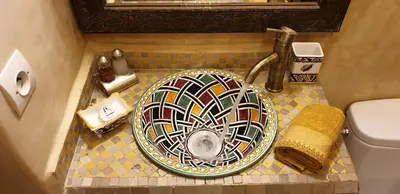 a bathroom with a mosaic sink and a toilet at Riad Souad Marrakech in Marrakech