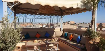 a bench on a balcony with a view of the city at Riad Souad Marrakech in Marrakech