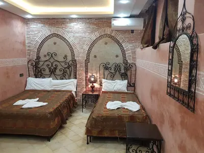 a room with two beds with towels on them at Hotel Salsabil in Marrakech