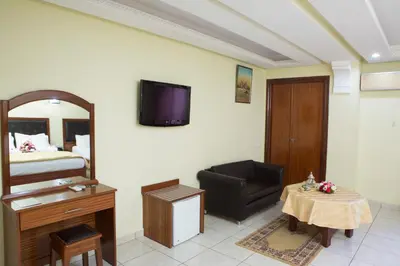 a room with a bed and a chair and a table at Hotel Gomassine in Marrakech