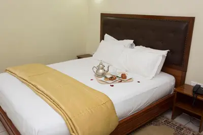 a bed with a tray of food on it at Hotel Gomassine in Marrakech