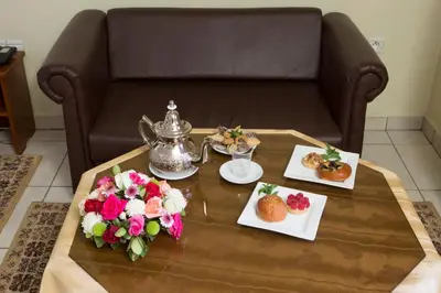 a coffee table with a tea kettle and plates of food at Hotel Gomassine in Marrakech