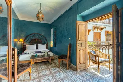 a bedroom with a bed and a table in a room at Riad Yamina52 in Marrakech