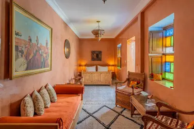 a living room with an orange couch and a bed at Riad Yamina52 in Marrakech