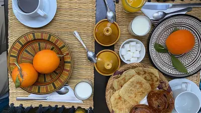 a table with plates of food and oranges on it at Riad Yamina52 in Marrakech