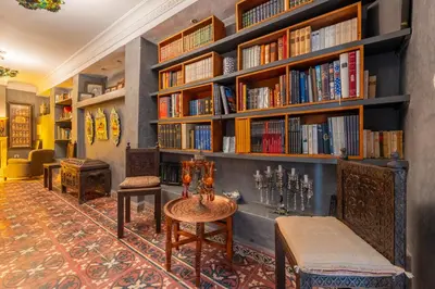 a library with book shelves and a table and chairs at Riad Yamina52 in Marrakech