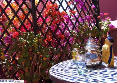 a table with a tea pot and some flowers at Nadir Home in Marrakech