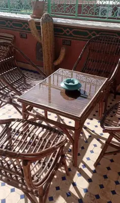 a wooden table with two chairs and a bowl on it at Charmant Riad avec piscine, au Coeur de Marrakech in Marrakech