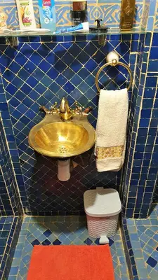 a bathroom with a gold sink and a toilet at Charmant Riad avec piscine, au Coeur de Marrakech in Marrakech