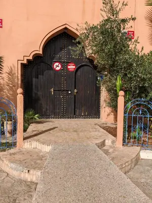 a large wooden door on a building at Charmant Riad avec piscine, au Coeur de Marrakech in Marrakech