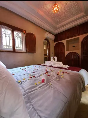 a bedroom with a large bed with flowers on it at Charmant Riad avec piscine, au Coeur de Marrakech in Marrakech