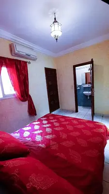 a large red bed in a bedroom with a window at Riad Prestigia in Marrakech