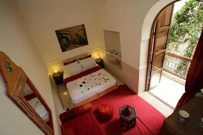 a bedroom with a bed and a large window at Riad white flowers in Marrakech