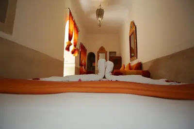 a bedroom with a large bed with white sheets at Riad white flowers in Marrakech