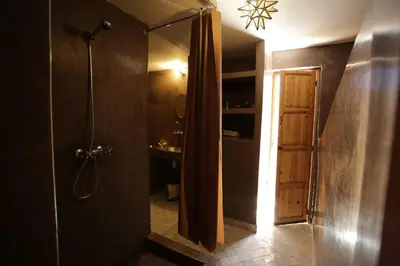 a bathroom with a shower and a shower curtain at Riad white flowers in Marrakech
