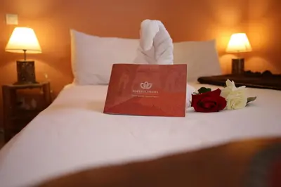 a sign on top of a bed with a rose on it at Riad white flowers in Marrakech