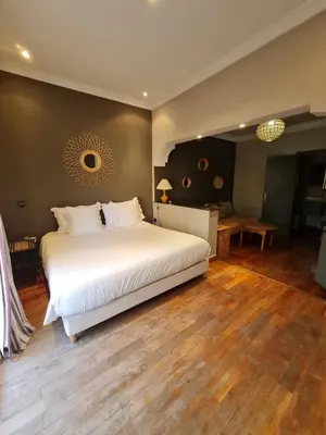 a bedroom with a large white bed and wooden floors at Villa Lila in Marrakech