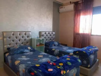 a bedroom with two twin beds and a window at Superbe appartement avec terrasse in Marrakech