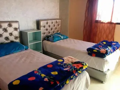 a bedroom with two beds with a blanket on them at Superbe appartement avec terrasse in Marrakech
