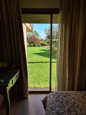 a bedroom with a door open to a yard at Appartement chic avec jardin a Prestigia Golf City in Marrakech