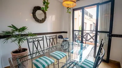 a balcony with two chairs and a glass table at Appartement aux portes de la palmeraie in Marrakech