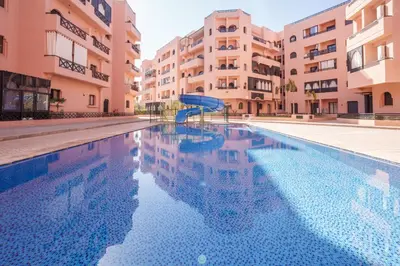 a swimming pool with a slide in the middle of a building at Appartement aux portes de la palmeraie in Marrakech