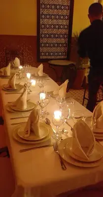 a long table with white plates and napkins and candles at New Bahia in Marrakech
