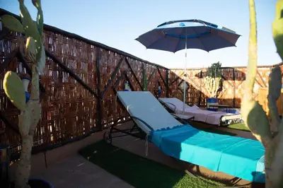 a patio with an umbrella and a chaise lounge and sidx sidx sidx at New Bahia in Marrakech