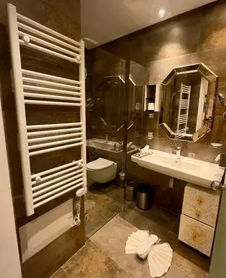 a bathroom with a sink and a toilet and a mirror at Sillage Palace Sky & Spa in Marrakech