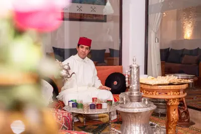 a man with a red hat sitting in a chair at Riad la clé d'or & spa in Marrakech