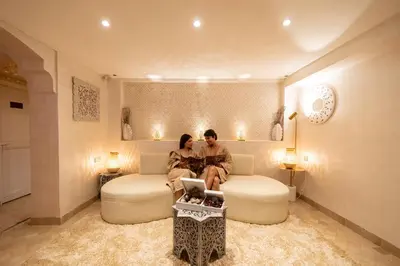 a man and woman sitting on a bed in a room at Riad la clé d'or & spa in Marrakech