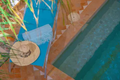 a straw hat sitting next to a swimming pool at Riad la clé d'or & spa in Marrakech
