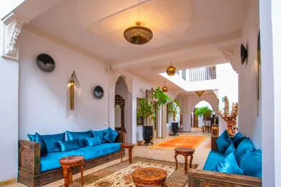 a living room with blue couches and tables at Riad la clé d'or & spa in Marrakech