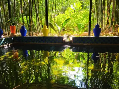 a fish pond with blue and yellow vases on top of it at Dar Sarah-Mouassine-Marrakech, Riad authentique idéalement situé in Marrakech