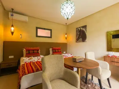 a bedroom with a bed and a table and chairs at RIAD REDWAN in Marrakech