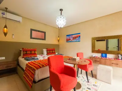 a bedroom with a bed and a table and chairs at RIAD REDWAN in Marrakech