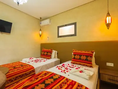 a hotel room with two beds with colorful blankets at RIAD REDWAN in Marrakech