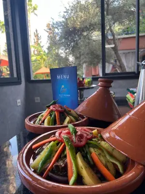 two dishes of vegetables on a table with a menu at RIAD REDWAN in Marrakech