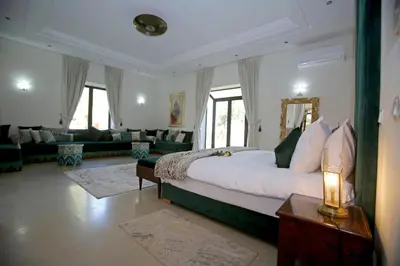 a bedroom with a large bed and a living room at Domaine DAR JMEL & Dar Abi Samama in Marrakech