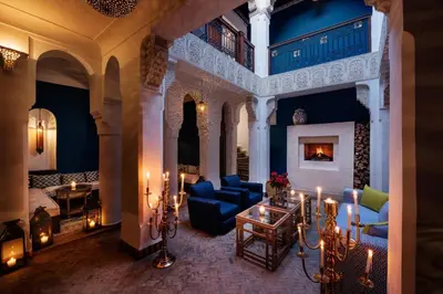 a living room filled with blue furniture and candles at Riad Les Yeux Bleus in Marrakech