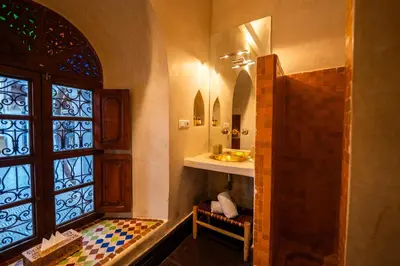 a bathroom with a shower and a sink and a window at Riad Les Yeux Bleus in Marrakech
